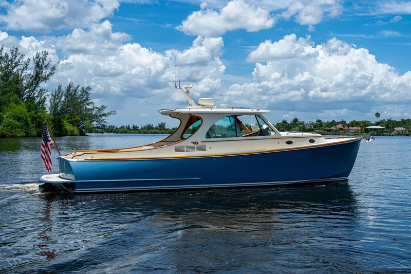 Slide: The Image of 2016 Hinckley Talaria 34 cruising on a scenic waterway under a blue sky. - 1