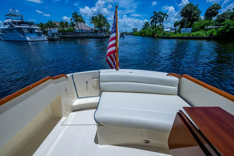 Slide: The Image of Hinckley Talaria 34 boat interior with American flag, scenic waterway view, 2016 model. - 14
