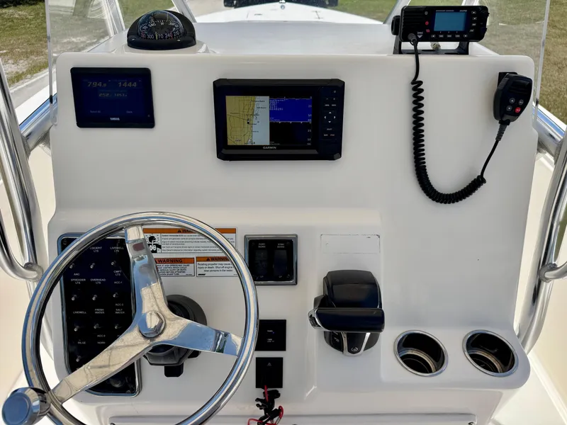 Slide: The Image of 2022 Cobia 237 Center Console dashboard with steering wheel, navigation screens, and controls. - 17