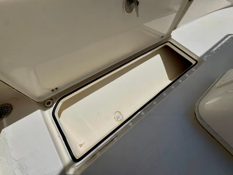 Slide: The Image of Open storage compartment on 2022 Cobia 237 Center Console boat. - 24