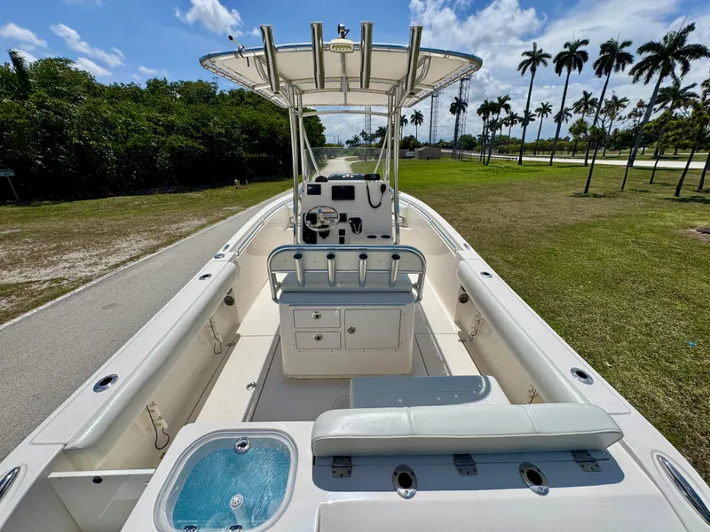 Slide: The Image of 2022 Cobia 237 Center Console boat with seating and console, parked on a sunny day. - 25