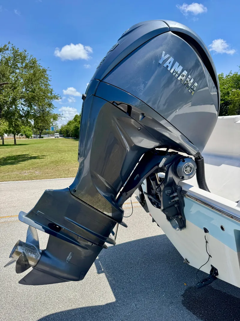 Slide: The Image of 2022 Cobia 237 Center Console with Yamaha outboard motor, parked on a sunny day. - 28