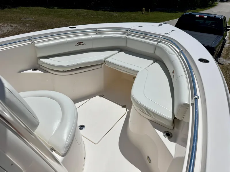 Slide: The Image of 2022 Cobia 237 Center Console boat with white cushioned seating and stainless steel railings. - 8