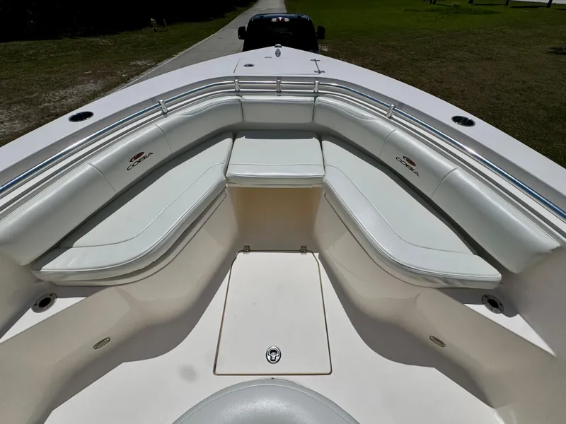 Slide: The Image of 2022 Cobia 237 Center Console boat with white cushioned seating and storage area. - 9