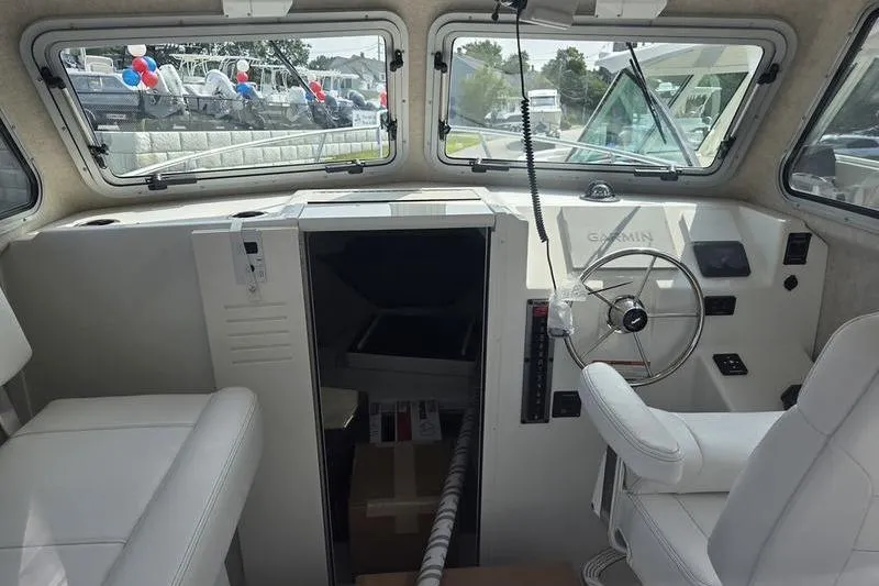 Slide: The Image of Interior of a 2025 Parker 2820 XLD boat with steering wheel and seating. - 11