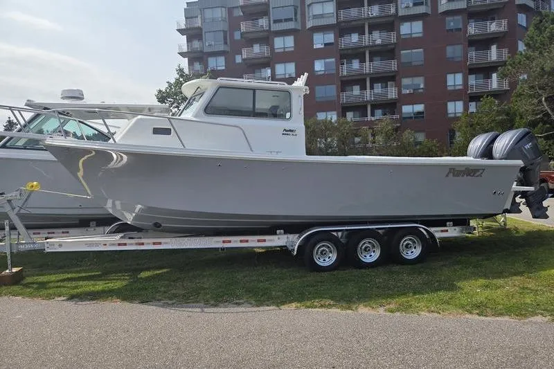 The Image of 2025 Parker 2820 XLD boat on trailer, parked near residential buildings. - 2