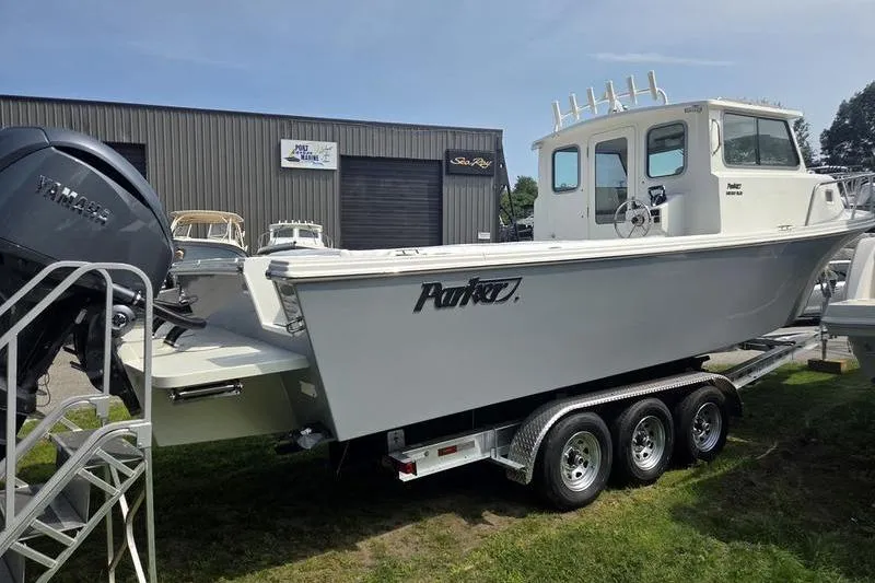 Slide: The Image of 2025 Parker 2820 XLD boat on trailer, displayed outdoors near a marine shop. - 7