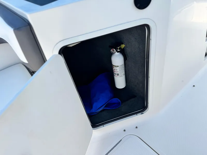 Slide: The Image of Storage compartment in 2015 Sea Ray 19 SPX boat with fire extinguisher and blue bag. - 16