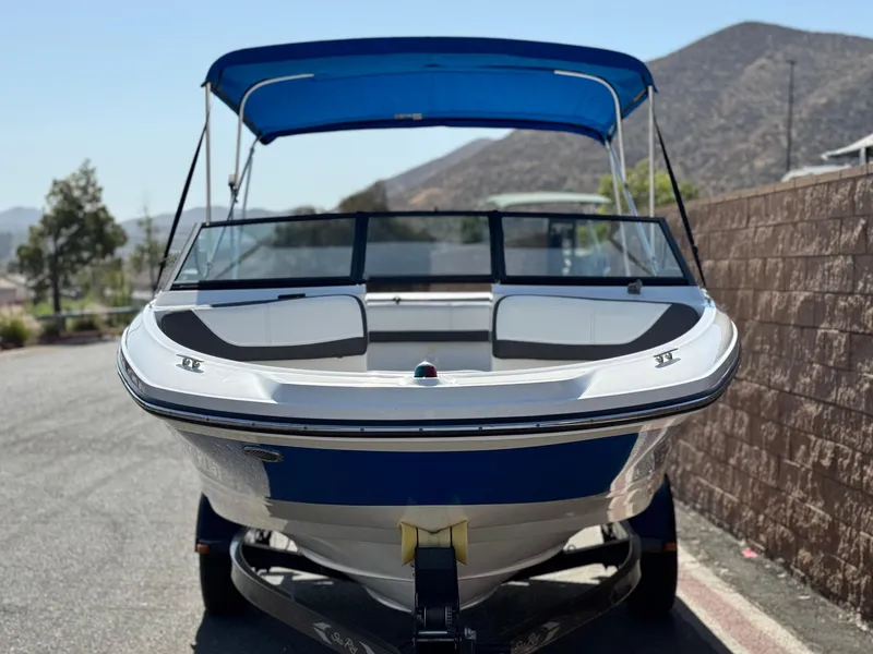 Slide: The Image of 2015 Sea Ray 19 SPX boat with blue canopy, parked on a sunny day. - 2