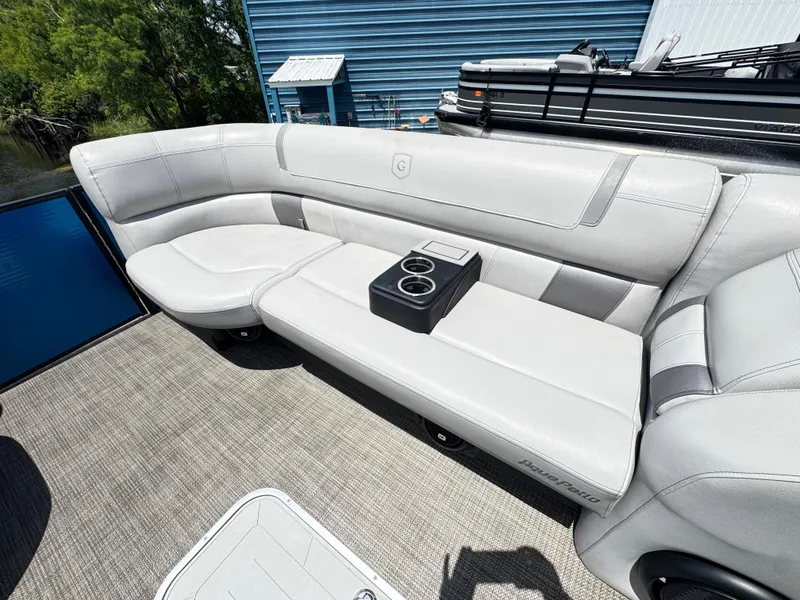 Slide: The Image of Luxurious seating on 2019 AquaPatio 259 DFL boat with cup holders, docked near blue building. - 11