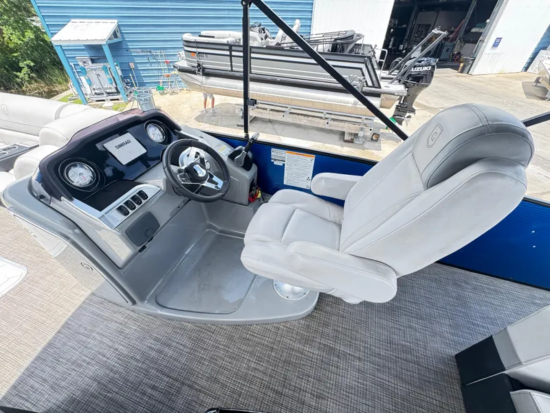 Slide: The Image of 2019 AquaPatio 259 DFL boat interior with steering console and captain's chair. - 3