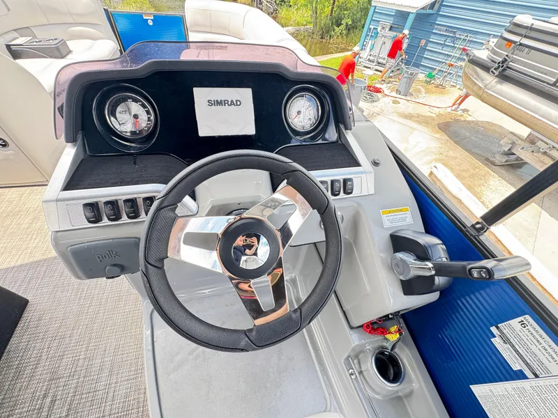 Slide: The Image of 2019 AquaPatio 259 DFL boat dashboard with steering wheel and controls. - 6