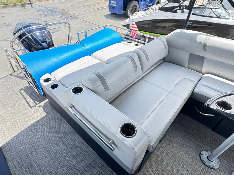 Slide: The Image of 2019 AquaPatio 259 DFL boat interior with gray seating and cup holders. - 9