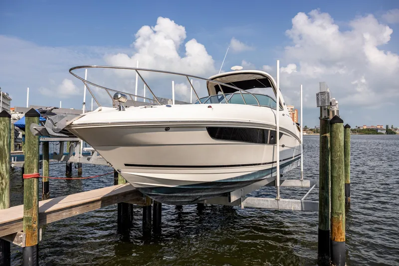 Slide: The Image of 2016 Sea Ray 310 Sundancer boat on lift, docked by waterfront. - 14