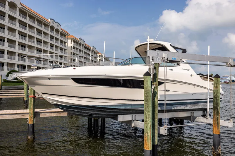 Slide: The Image of 2016 Sea Ray 310 Sundancer boat docked near waterfront buildings. - 16