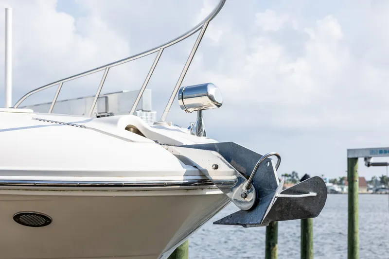 Slide: The Image of 2016 Sea Ray 310 Sundancer boat bow with anchor, docked by the water. - 17