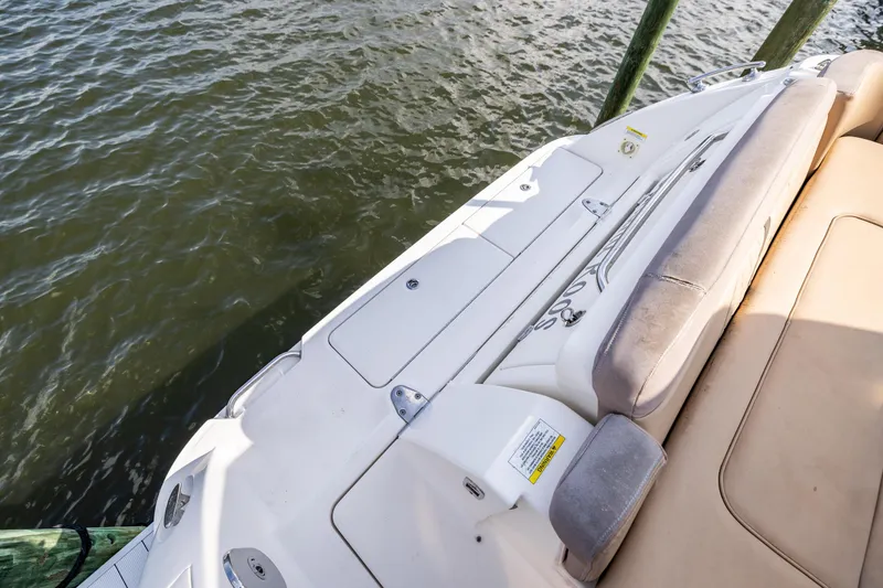 Slide: The Image of 2016 Sea Ray 310 Sundancer boat deck with seating, docked by water. - 18