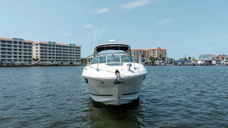 Slide: The Image of 2016 Sea Ray 310 Sundancer boat on water with buildings in background. - 2