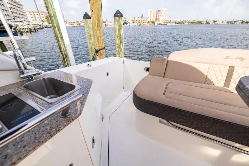 Slide: The Image of 2016 Sea Ray 310 Sundancer boat interior with sink and seating by the water. - 20
