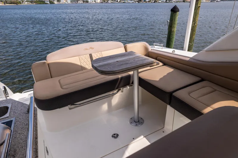Slide: The Image of 2016 Sea Ray 310 Sundancer boat interior with seating and table by the water. - 24