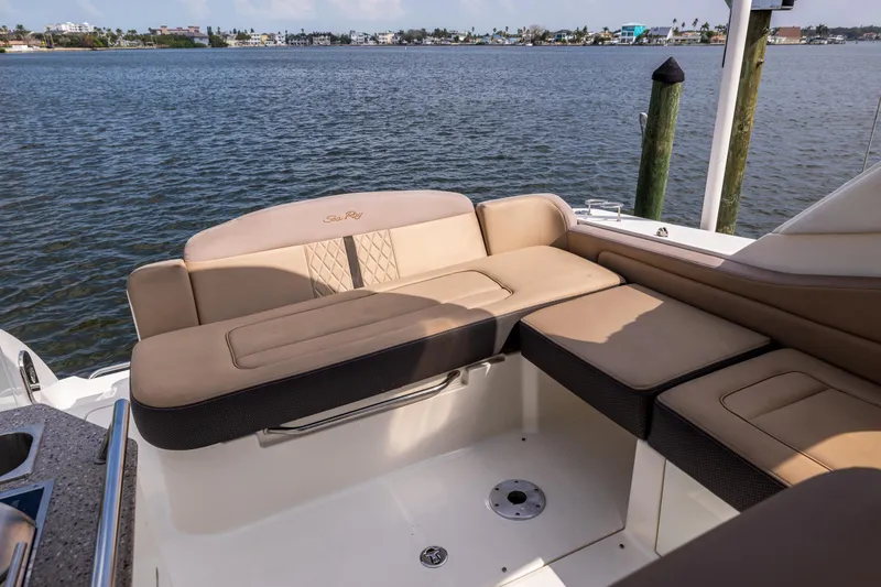 Slide: The Image of 2016 Sea Ray 310 Sundancer boat interior with beige seating, overlooking calm waters. - 25