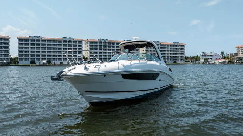 Slide: The Image of 2016 Sea Ray 310 Sundancer boat on water with buildings in background. - 3