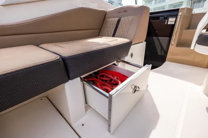 Slide: The Image of 2016 Sea Ray 310 Sundancer interior with open storage drawer and seating. - 32