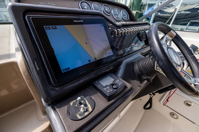 Slide: The Image of 2016 Sea Ray 310 Sundancer helm with navigation display and steering wheel. - 42