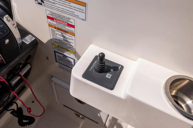 Slide: The Image of Control panel of a 2016 Sea Ray 310 Sundancer boat with joystick and warning labels. - 44