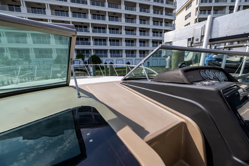 Slide: The Image of 2016 Sea Ray 310 Sundancer boat docked near waterfront buildings. - 46