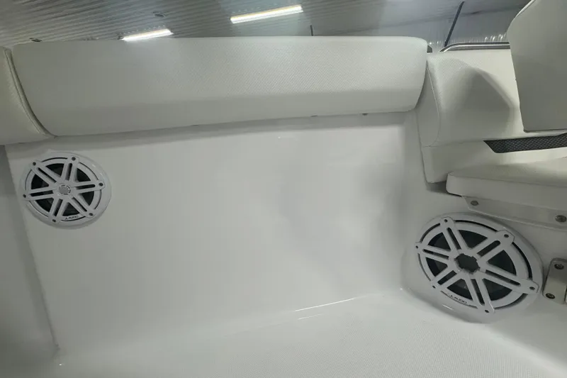 Slide: The Image of 2025 Wellcraft 243 Fisherman boat interior with white speakers and cushioned seating. - 10