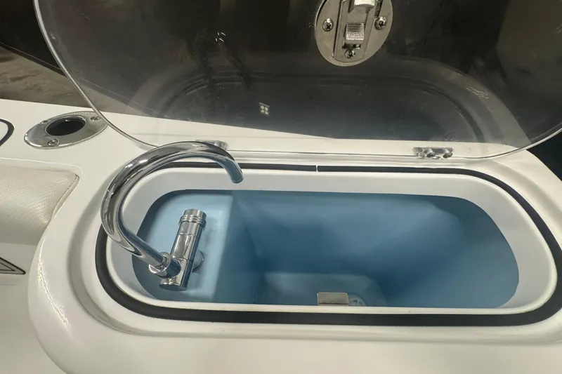 Slide: The Image of Livewell compartment on 2025 Wellcraft 243 Fisherman boat, featuring a chrome faucet. - 12