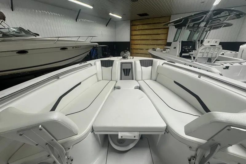 Slide: The Image of 2025 Wellcraft 243 Fisherman boat interior with white seating in a showroom. - 4