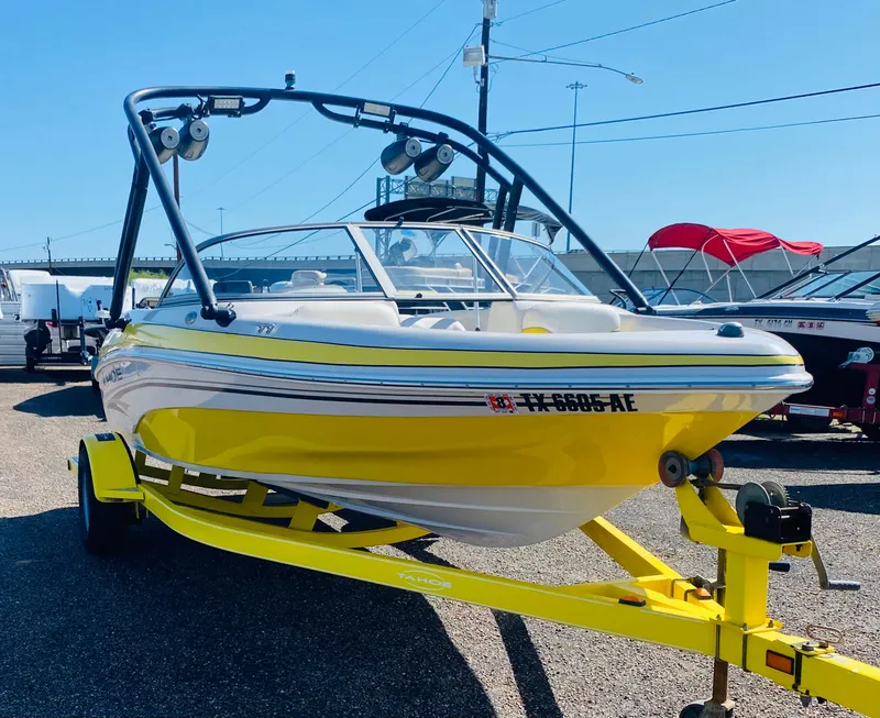 The Image of 2006 Tahoe Q4 Sport boat in bright yellow on trailer, parked outdoors. - 0