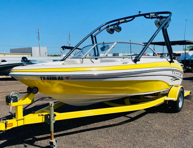 Slide: The Image of 2006 Tahoe Q4 Sport boat in yellow on trailer, parked outdoors. - 1