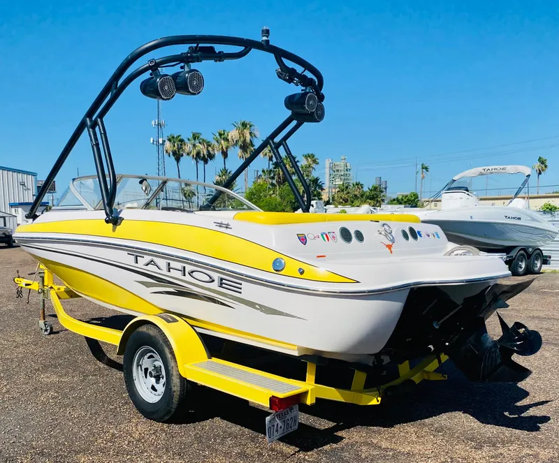 Slide: The Image of 2006 Tahoe Q4 Sport boat with yellow accents on a trailer, parked outdoors. - 3