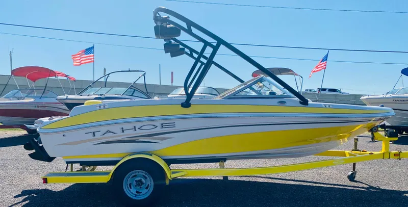Slide: The Image of 2006 Tahoe Q4 Sport boat in yellow on trailer, with American flags in background. - 4