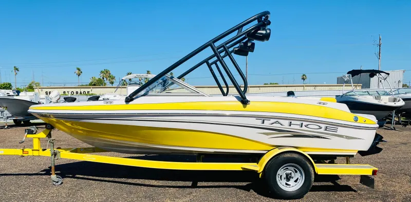 Slide: The Image of 2006 Tahoe Q4 Sport boat in yellow and white on a trailer, parked outdoors. - 5