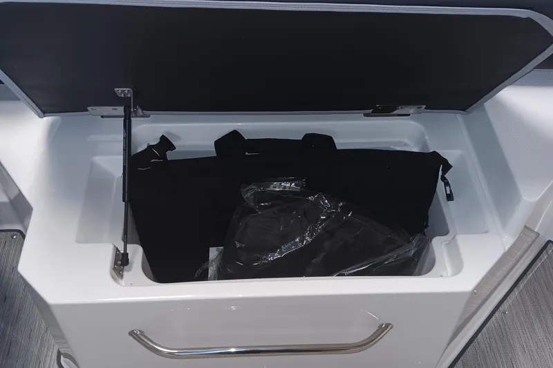 Slide: The Image of Open storage compartment in 2025 Cobalt R6 boat, featuring black bag inside. - 21