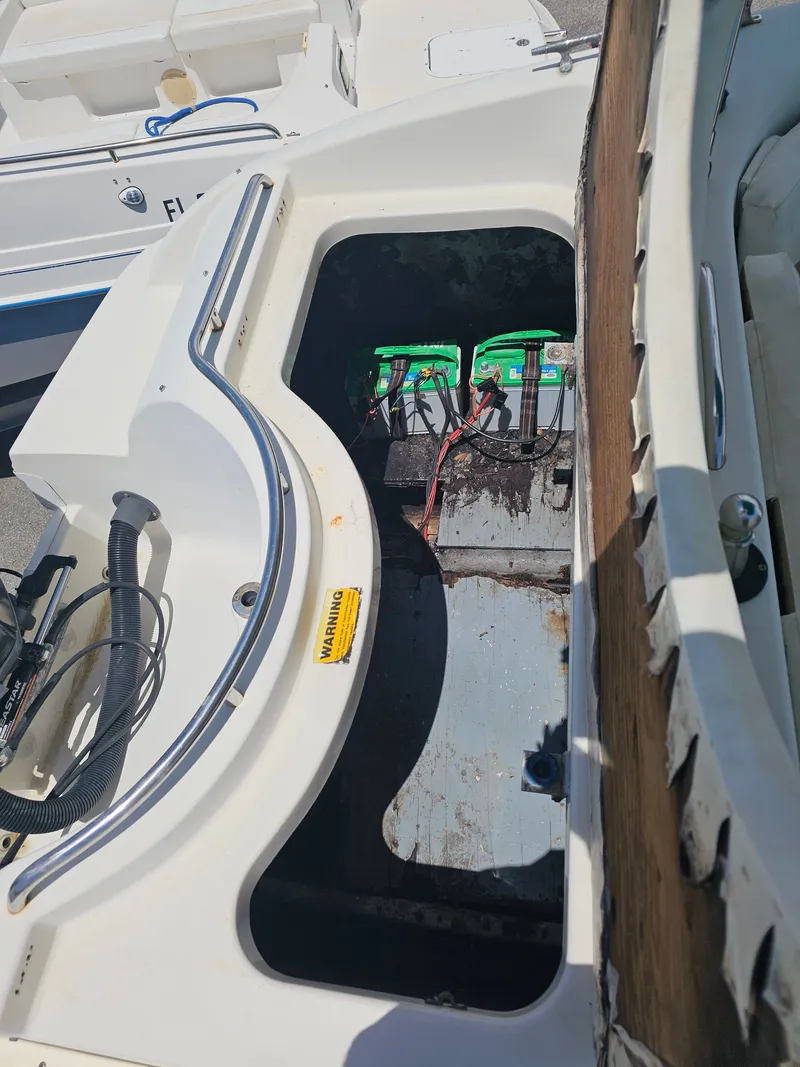Slide: The Image of 1996 Bayliner 2609 Rendezvous boat battery compartment with visible wiring and warning label. - 20