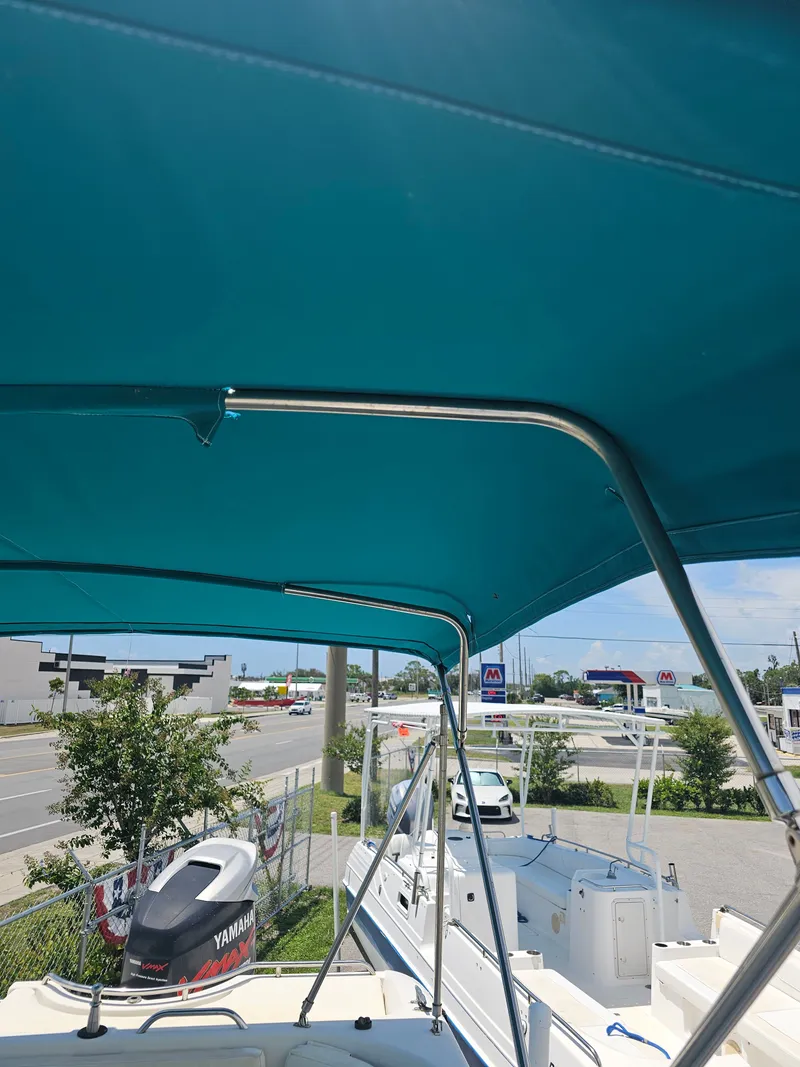 Slide: The Image of 1996 Bayliner 2609 Rendezvous boat with blue canopy, parked near Yamaha outboard motor. - 25