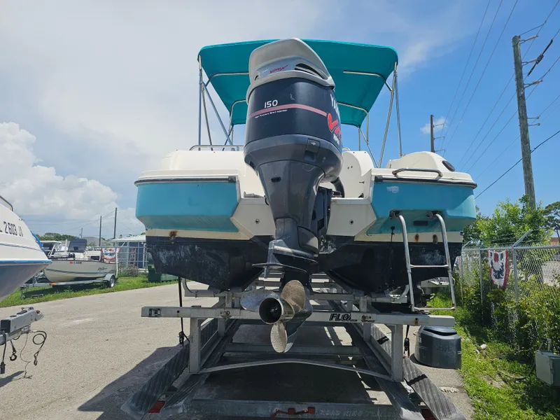 Slide: The Image of 1996 Bayliner 2609 Rendezvous boat on trailer with outboard motor, parked outdoors. - 31