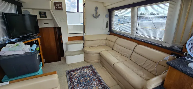 Slide: The Image of Interior of 2000 Carver 356 Aft Cabin Motor Yacht with beige leather seating and TV. - 19