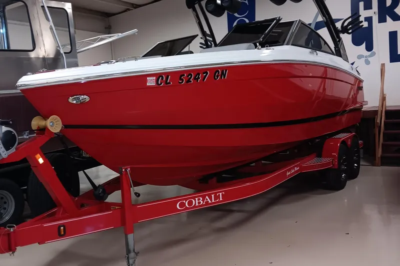 The Image of Red 2023 Cobalt R4 boat on trailer in showroom. - 1