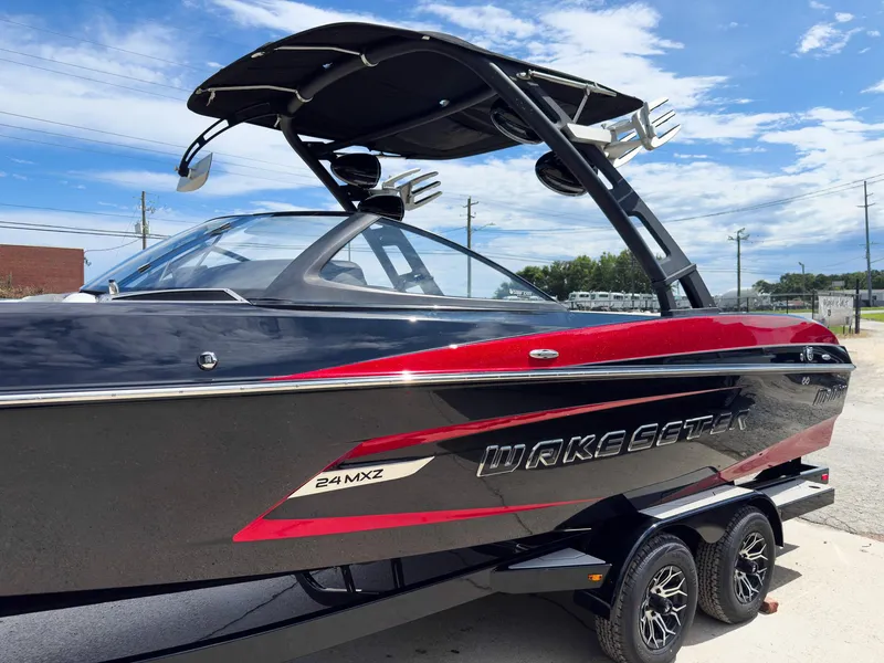 Slide: The Image of 2015 Malibu Wakesetter 24 MXZ boat with sleek black and red design on trailer. - 10