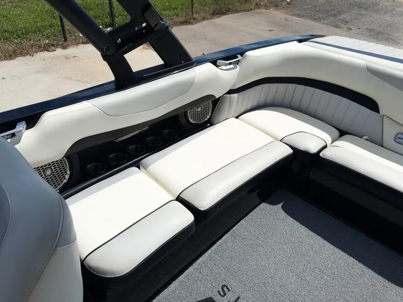 Slide: The Image of 2015 Malibu Wakesetter 24 MXZ interior with white leather seating and cup holders. - 25