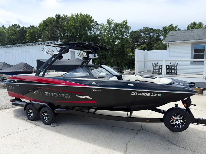 Slide: The Image of 2015 Malibu Wakesetter 24 MXZ boat on trailer, parked outdoors. - 3