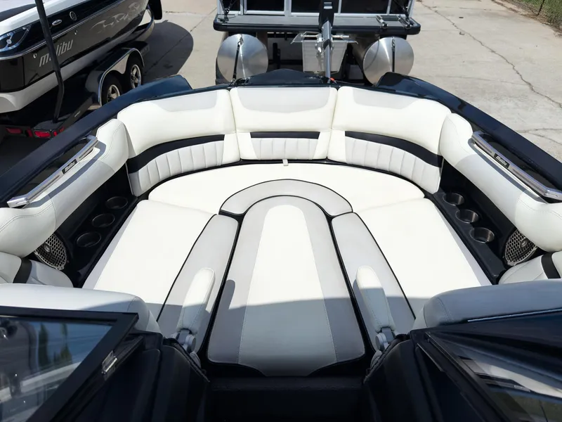 Slide: The Image of 2015 Malibu Wakesetter 24 MXZ boat interior with white and black seating. - 33