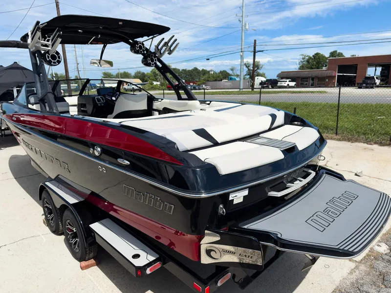 Slide: The Image of 2015 Malibu Wakesetter 24 MXZ boat with sleek design, parked on a trailer. - 9