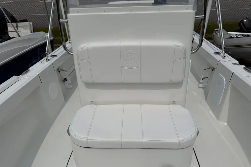 Slide: The Image of 2025 Parker 181 SHOAL boat interior with white cushioned seating and steering console. - 12